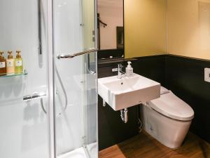 ein Bad mit einem Waschbecken, einem WC und einer Dusche in der Unterkunft Vessel Inn Hakata Nakasu in Fukuoka