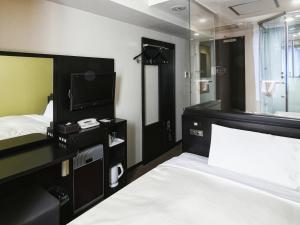 福岡市にあるベッセルイン博多中洲のベッドとテレビが備わるホテルルームです。
