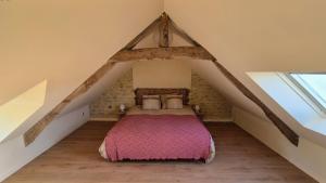 ein Schlafzimmer mit einem Bett auf einem Dachboden in der Unterkunft L'Arromanchaise - Gold Beach in Arromanches-les-Bains