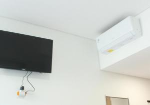 a flat screen tv hanging on a white wall at OFO Kost Premium Syariah Kampung Inggris Pare in Pare