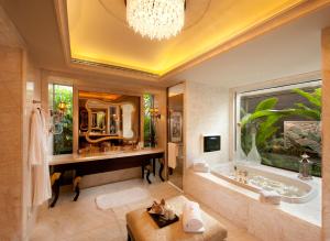 La salle de bains est pourvue d'une baignoire et d'un grand miroir. dans l'établissement Wanda Reign Resort & Villas Sanya Haitang Bay, à Sanya