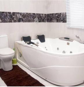 a white bath tub in a bathroom with a toilet at BTT Homes in Lekki