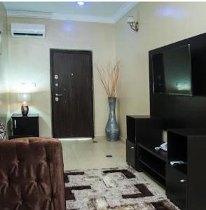 a living room with a couch and a television at BTT Homes in Lekki