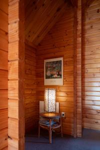 Habitación de madera con silla y lámpara en Fox Glacier Lodge, en Fox Glacier