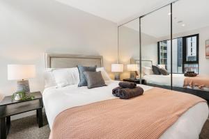 a large bedroom with two beds and two lamps at Stay in Luxury at Stature - Sleeps 5 in Melbourne