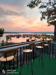 a balcony with chairs and a view of the water at บ้านสวนริมน้ำวังใหญ่ ห้อง a1 วังสามหมอ อุดรธานี in Ban Tha Ngam