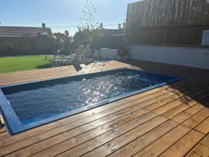 una piscina en una terraza de madera en מבית תכלת בית של חופש Allentown 21 אלנטאון 21 en Tiberias