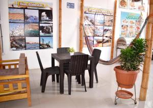 a dining room with a black table and chairs at Hospedaje El Buen Samaritano in Paracas