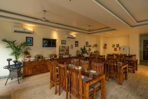uma sala de jantar com mesas e cadeiras de madeira em Moustache Rishikesh Luxuria em Rishikesh