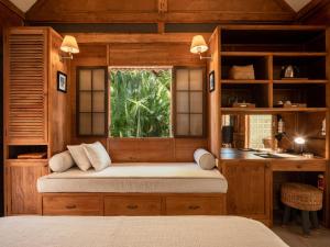 een slaapkamer met een bed, een raam en een bureau bij Nido Boutique Cottage by BaliSuperHost in Canggu