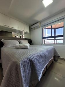 a bedroom with a large bed and a large window at Apart-hotel 36m² Varanda Vista Mar no Cabo Branco in João Pessoa
