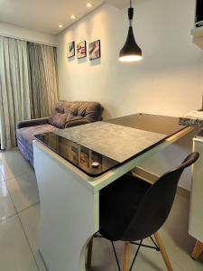 a desk with a chair in a room with a couch at Apart-hotel 36m² Varanda Vista Mar no Cabo Branco in João Pessoa
