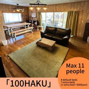 a living room with a couch and a table at 100泊で完成する民泊 in Takamori