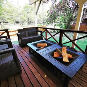 a fire pit on a deck with logs on it at 100泊で完成する民泊 in Takamori