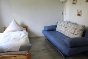 een woonkamer met een blauwe bank en een kussen bij Ferienwohnung Egelkraut in Schwarzenbach an der Saale