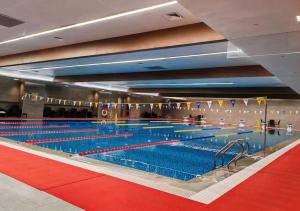 une grande piscine avec des voies bleues et rouges dans l'établissement Beijing CSN Pearl Hotel, à Pékin