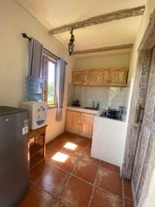 eine kleine Küche mit einem Kühlschrank und einem Fenster in der Unterkunft Mango 5 Hotel in Amed
