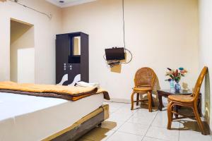 BangkoにあるRedDoorz @ Hotel Keluarga Bangkoのベッドルーム1室(ベッド1台、テーブル、椅子付)