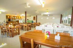 a restaurant with wooden tables and chairs and a dining room at Phuket Airport Villa in Phuket Town