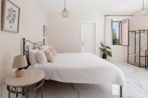biała sypialnia z białym łóżkiem i stołem w obiekcie Corfu Town Luxury Studio -B - New w Korfu