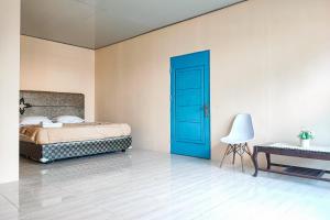 um quarto com uma cama e uma porta azul em RedDoorz @ Hotel Keluarga Bangko em Bangko