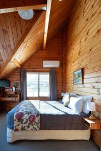 a bedroom with a bed in a wooden cabin at Fox Glacier Lodge in Fox Glacier