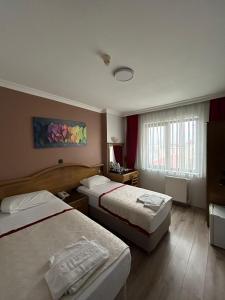 a hotel room with two beds and a window at Nil Hotel in Gaziantep