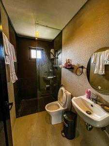 a bathroom with a toilet and a sink and a shower at The Pacific Coast in Boracay
