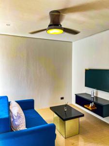 長灘島的住宿－The Pacific Coast，客厅配有蓝色的沙发和平面电视。