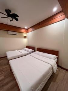 a bedroom with two beds and a ceiling fan at Tabularasa - T Luxury Boutique in New Agutaya