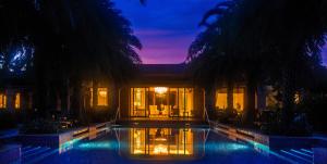 a house with a swimming pool at night at Wanda Reign Resort & Villas Sanya Haitang Bay in Sanya