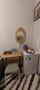 Zimmer mit einem Tisch, einem Spiegel und einem Kühlschrank. in der Unterkunft Fener sweet in Istanbul