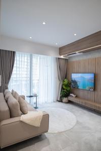 a living room with a couch and a flat screen tv at Midtown Apartments by Saigon - Phú Mỹ Hưng in Ho Chi Minh City