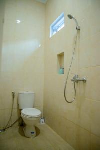 a bathroom with a toilet and a shower at RedDoorz syariah near Universitas Islam Riau in Pekanbaru