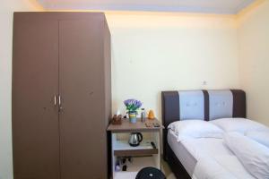 a bedroom with two beds and a night stand with a table at RedDoorz syariah near Universitas Islam Riau in Pekanbaru