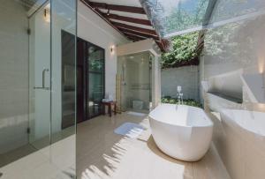 a bathroom with a large white tub and a sink at BuBu Villa in Perhentian Islands