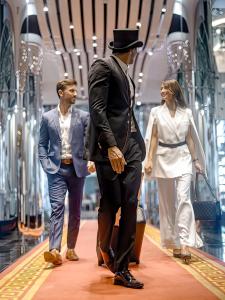 Un homme dans un haut chapeau et une femme dans un magasin dans l'établissement Golden Sands Boutique Hotel-Dubai Creek, à Dubaï