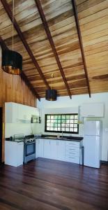 Il comprend une cuisine avec des placards blancs et un plafond en bois. dans l'établissement Casa Arthémis -Fast Wifi, à Guápiles