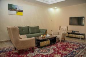 アル・ブライミにあるAl Salam Grand Hotel & Resortのリビングルーム(緑のソファ、椅子2脚付)