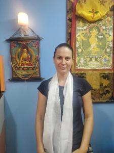 STUPA VIEW INN في كاتماندو: امرأة ترتدي وشاح تقف في غرفة مع لوحات