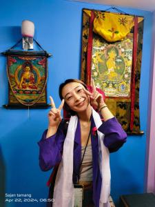 a woman making the peace sign with her hands at STUPA VIEW INN in Kathmandu