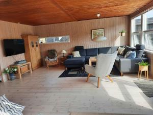 un soggiorno con divano blu e TV di Cozy Summer House In Lnstrup For 5 People, a Lønstrup