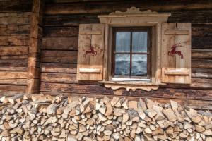 ein Fenster an der Seite eines Blockhauses in der Unterkunft Alpengasthof Karalm in Rauris