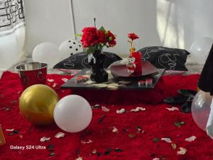 una mesa con un jarrón de flores y globos en DREAMLAND GUEST HOUSe en Mafikeng