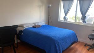 ein Schlafzimmer mit einem blauen Bett und einem Fenster in der Unterkunft Westminster Zen Home in Westminster