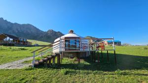 a gazebo in a field with a house at Magic Rock Tourist Camp in Nalayh