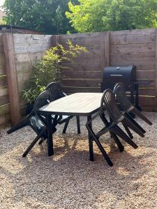 ein Picknicktisch, zwei Stühle und ein Grill in der Unterkunft Nature et Moi in Wittes