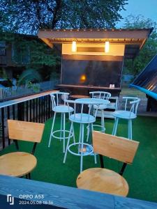 un patio avec des tables, des tabourets et un grill dans l'établissement บ้านสวนริมน้ำวังใหญ่ วังสามหมอ อุดรธานี, 