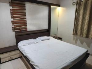 a bedroom with a large white bed with a window at Luxurious 2BHK villa with garden in Solapur