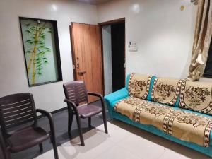Cette chambre comprend un canapé et des chaises. dans l'établissement Luxurious 2BHK villa with garden, à Solapur